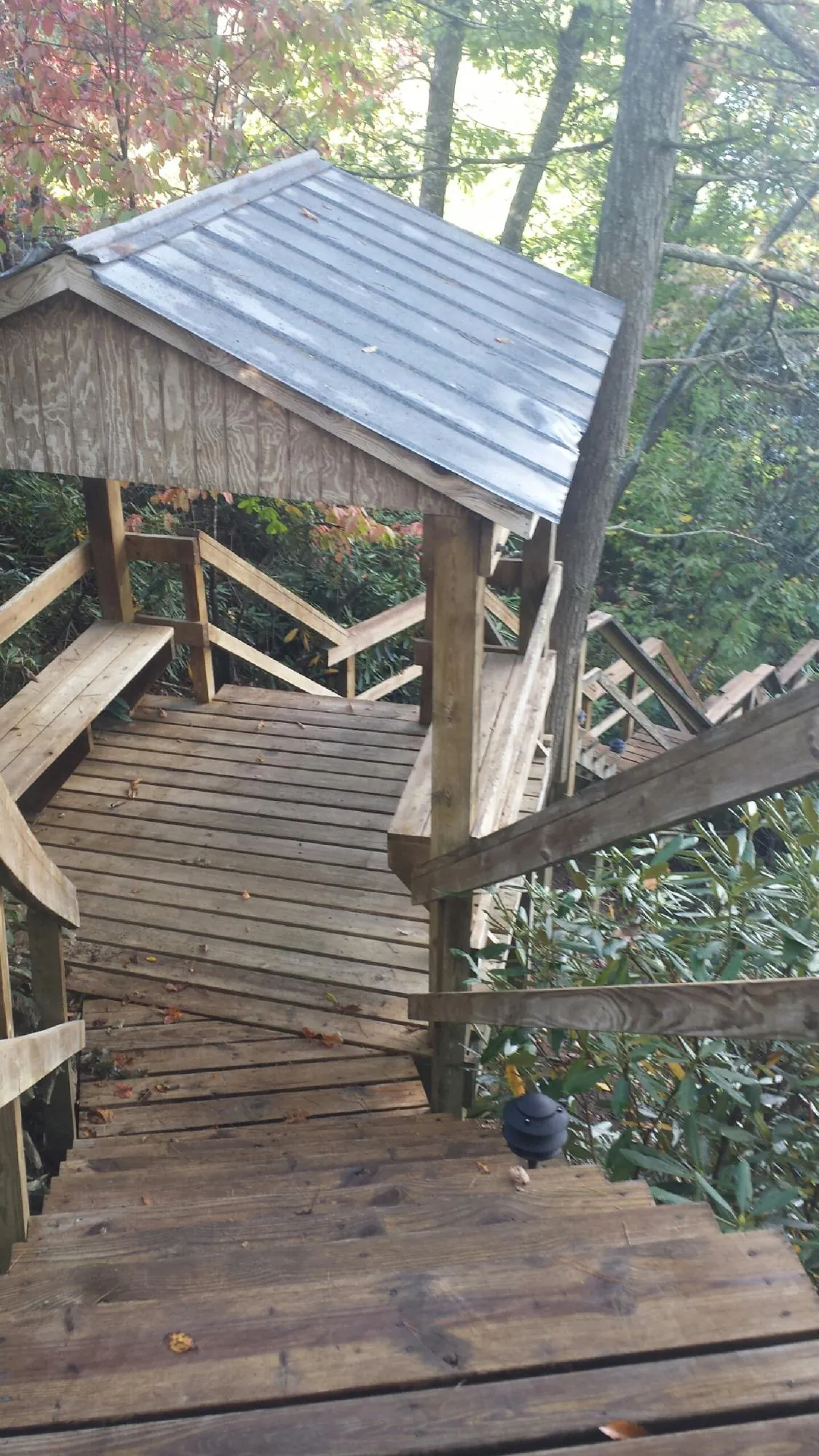 Metal roofed shelter over wooden steps on a wooded walkway — Skylight Repair & Installation work by our crew in Notre Dame
