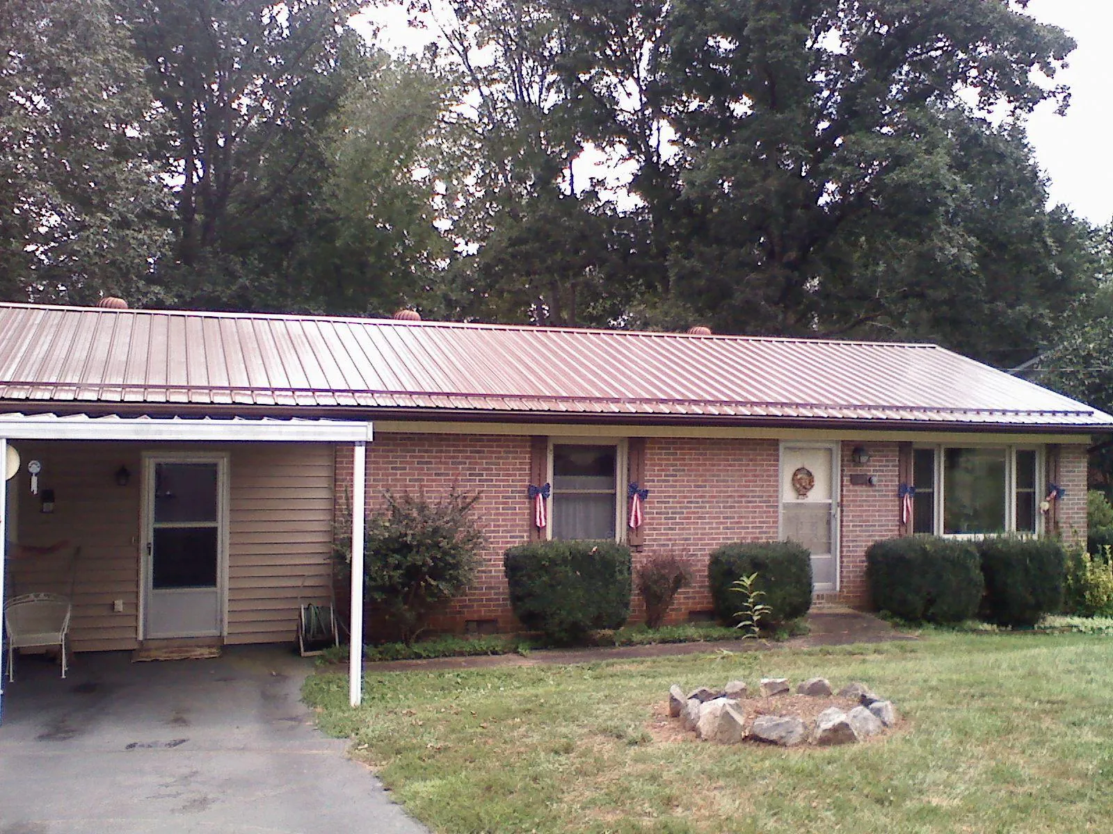 Bronze metal roof and carport on a brick ranch home — Roof Repair work by our crew in Notre Dame